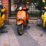 Een moderne 3-wiel scootmobiel in een stedelijke omgeving, ideaal voor ouderen en mensen die extra stabiliteit wensen.