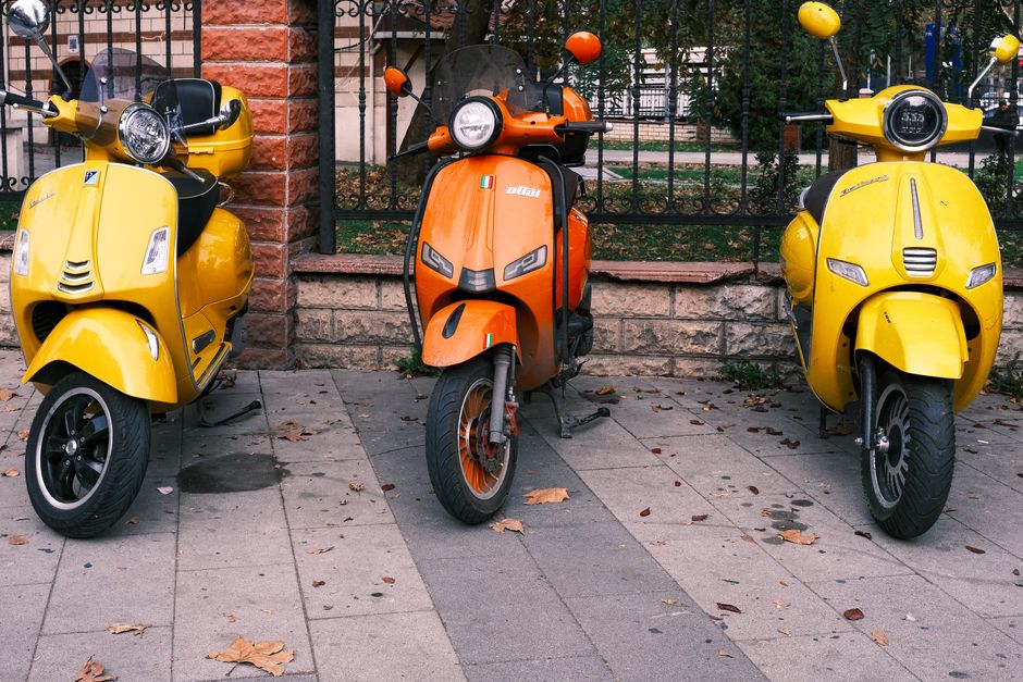Een moderne 3-wiel scootmobiel in een stedelijke omgeving, ideaal voor ouderen en mensen die extra stabiliteit wensen.